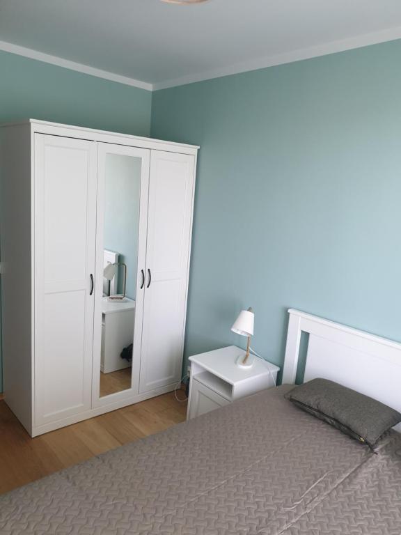 een slaapkamer met een bed en een witte kast bij Ozolu apartement in Kandava