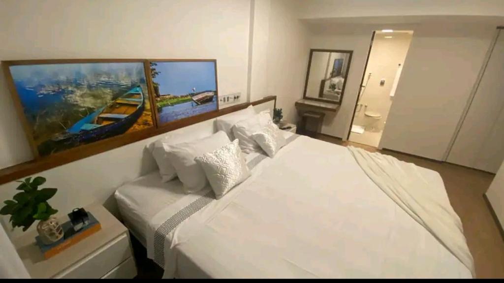 Un dormitorio con una cama blanca con un cuadro en la pared. en Ondina Apart Hotel, en Salvador