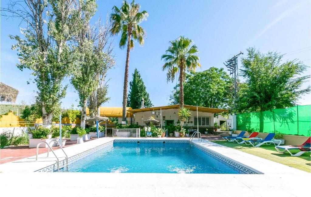einen Pool mit Palmen und ein Haus in der Unterkunft Nice Home In Lucena With Outdoor Swimming Pool in Lucena