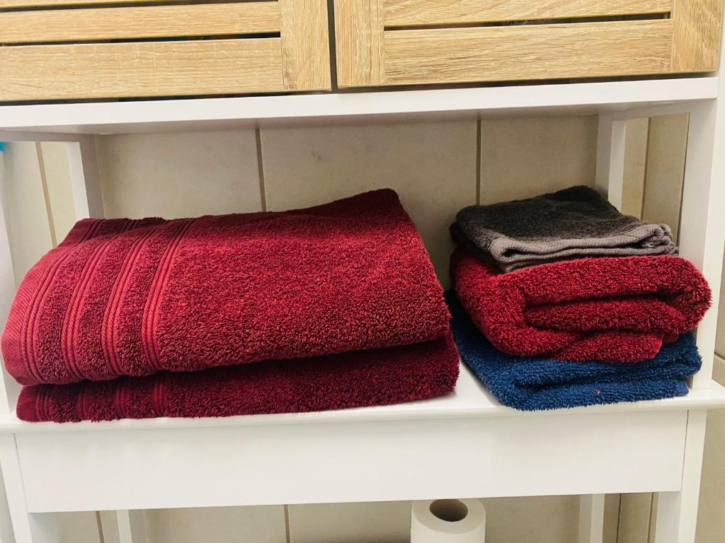 three towels are sitting on a shelf in a bathroom at Studio centre village Soligny la Trappe proche Mortagne au perche in Soligny-la-Trappe