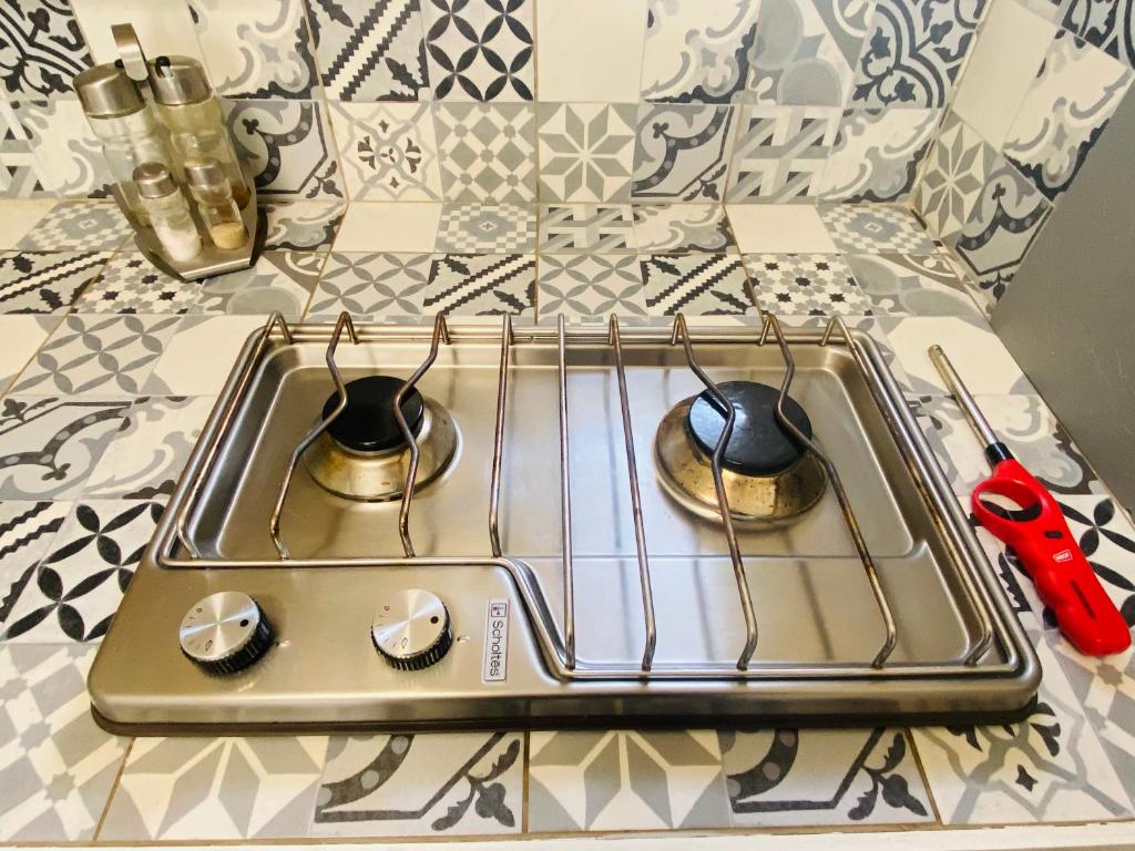 a stove top with two pots and a pair of scissors at Studio centre village Soligny la Trappe proche Mortagne au perche in Soligny-la-Trappe