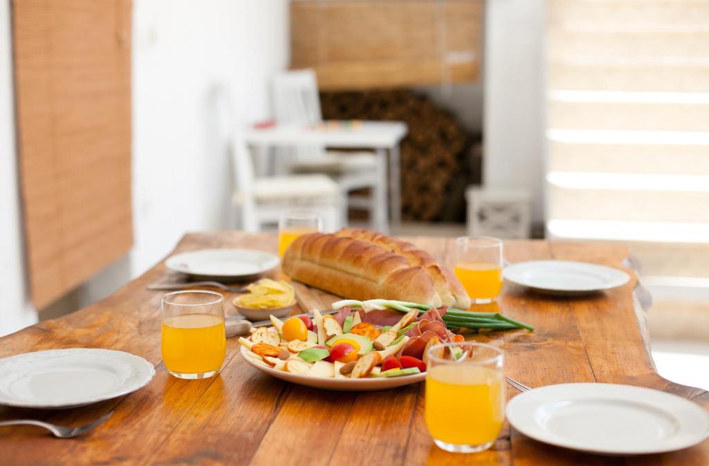 a table with a plate of food and orange juice at Kućica u cvijeću in Imotski