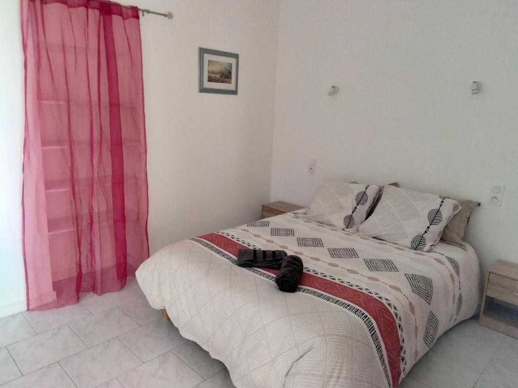 een slaapkamer met een bed met een rood gordijn bij Appartement calme a 2 minutes a pieds du centre ville in Manosque