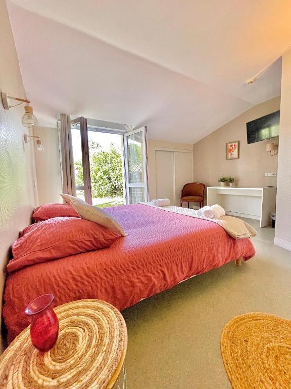 une chambre avec un grand lit et une fenêtre dans l'établissement Chambres Domaine de Laléard, à Saint-Hilaire-de-Villefranche