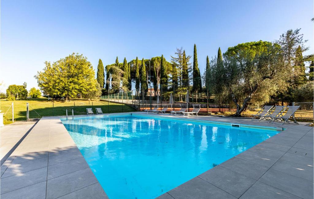 une grande piscine bleue avec des chaises et des arbres dans l'établissement Villa Tiglio, à San Gervasio