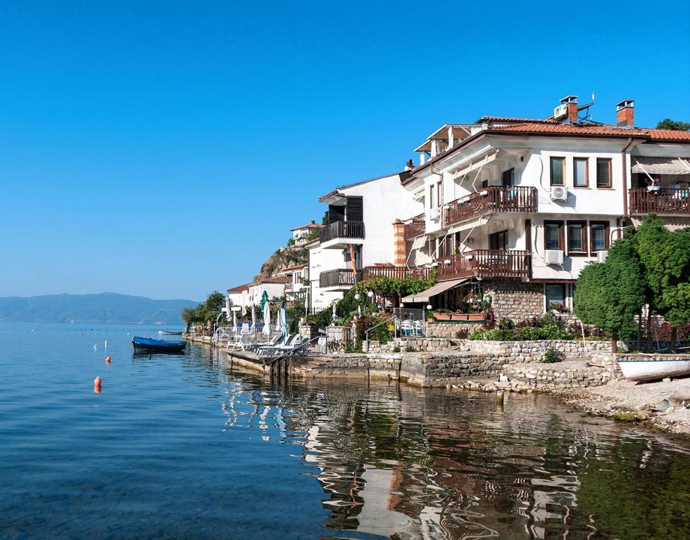 un grupo de casas en la orilla de un cuerpo de agua en Villa Malezan en Ohrid