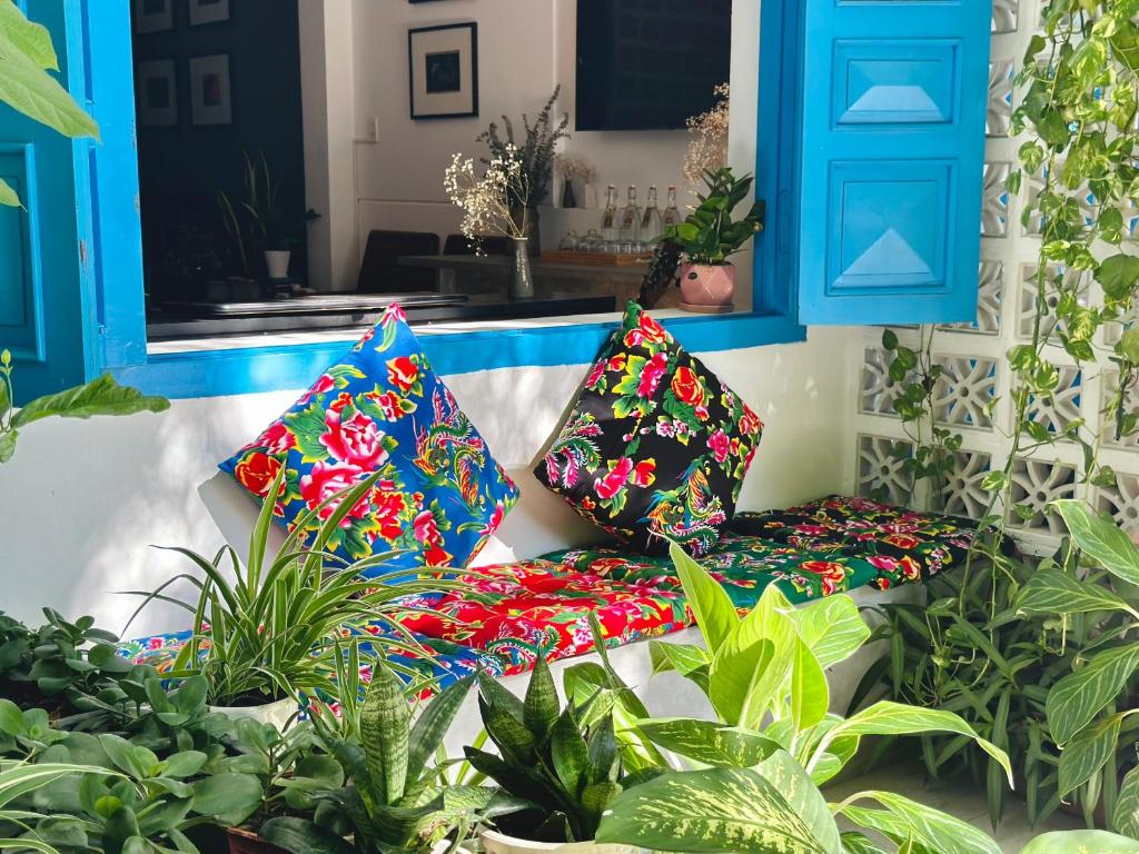 un banc avec des oreillers colorés assis dans un jardin dans l'établissement Loka Home & Yoga, à Đà Nẵng