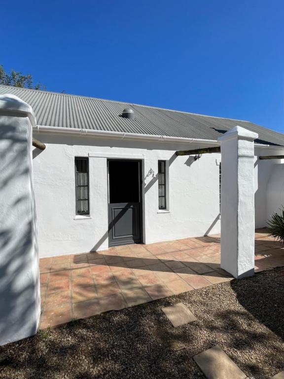 a white house with a door and a porch at 13 On Vigne in Greyton