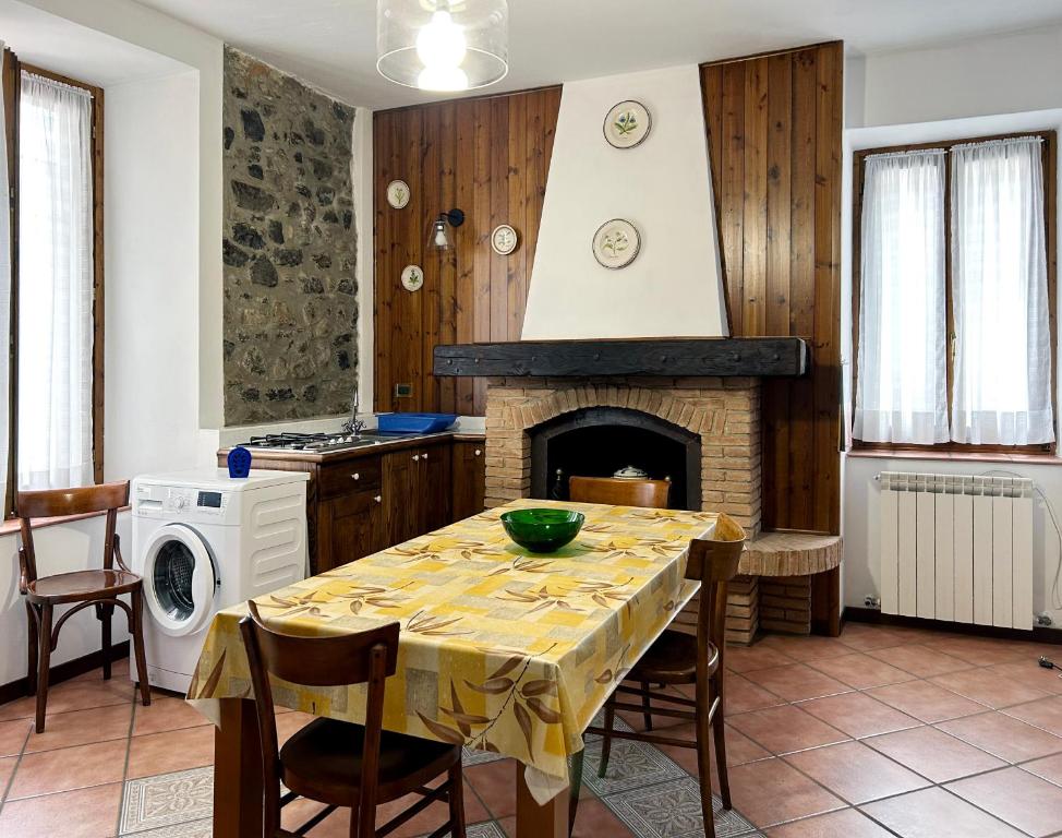a kitchen with a table and a fireplace at Barzio Village Hideaway in Barzio