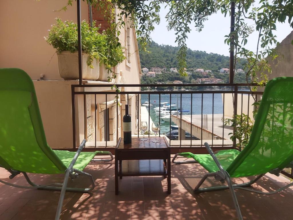 - un balcon avec deux chaises vertes et une table avec vue dans l'établissement Apartment Nela, à Brna