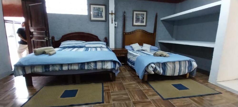 two beds in a bedroom with blue walls at La casa Jorge & Marvin in Cancún
