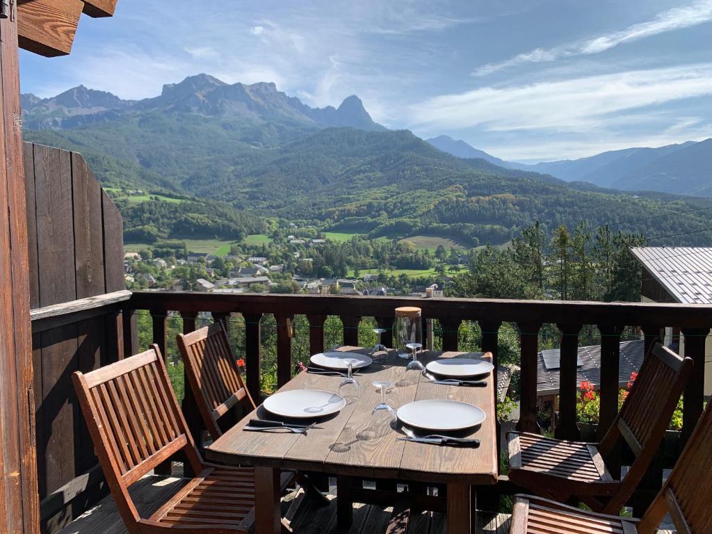a table on a balcony with a view of mountains at Le Tremplin 61 in Barcelonnette