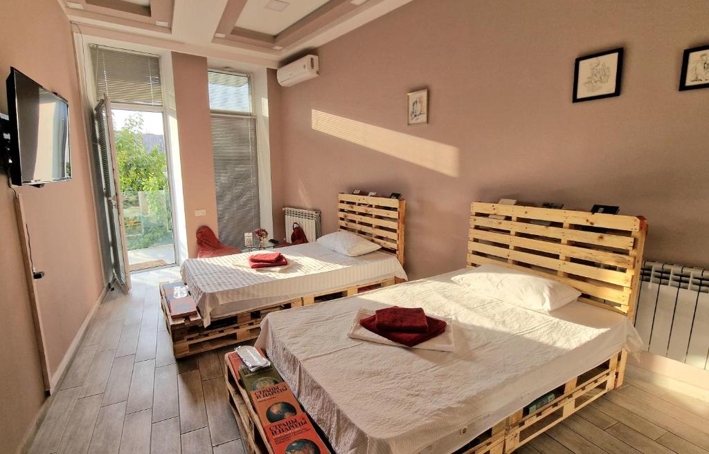 1 dormitorio con 2 camas y TV de pantalla plana en Puzzle Space, en Ereván