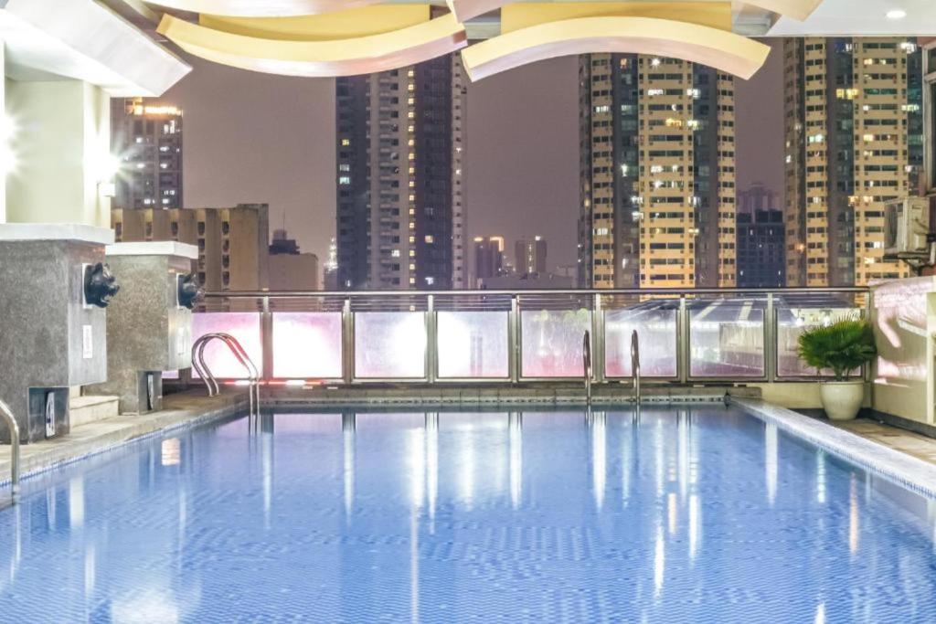 a large swimming pool on the roof of a building at Near US Embassy - Free Sauna & Pool Access + 20% Off Promo This Month! Explore Deluxe Studio Unit in Manila w/ Balcony Perfectly Situated Near NAIA Airport, Heart of Manila - Updated 2023 Price for Your Unforgettable Ultimate Staycation Experience! in Manila