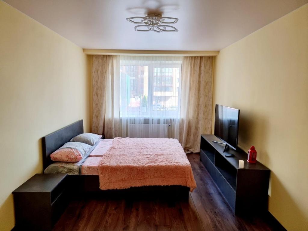 a bedroom with a bed and a tv and a window at Яровиця 2 кімнати in Lutsk