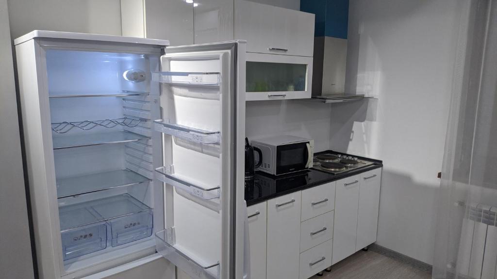 a refrigerator with its door open in a kitchen at APARTMENT - КВАРТИРА NEW in Tashkent