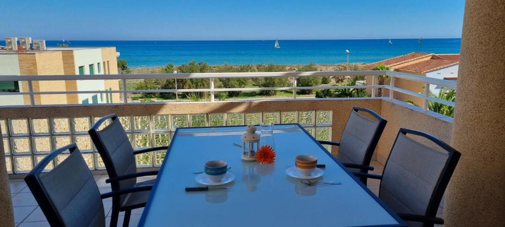 Apartamento Junto al Mar في أوليفا: طاولة زرقاء وكراسي على شرفة مع المحيط