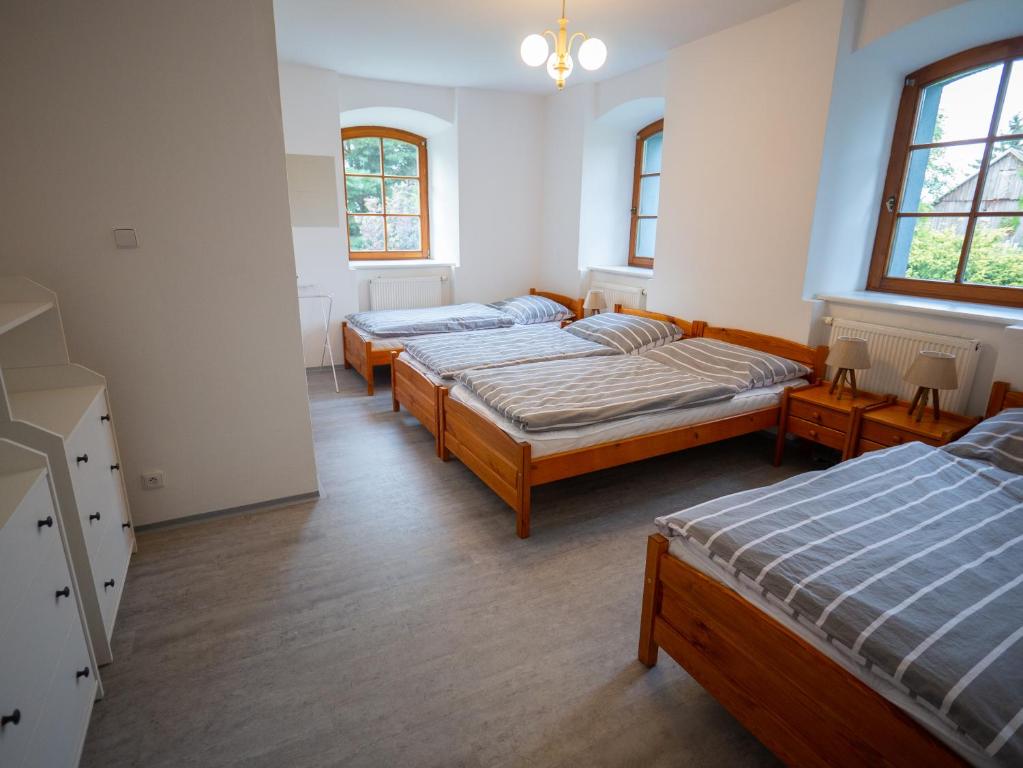 a room with three beds and two windows at Rodinná chalupa Ostašovka Liberec in Liberec