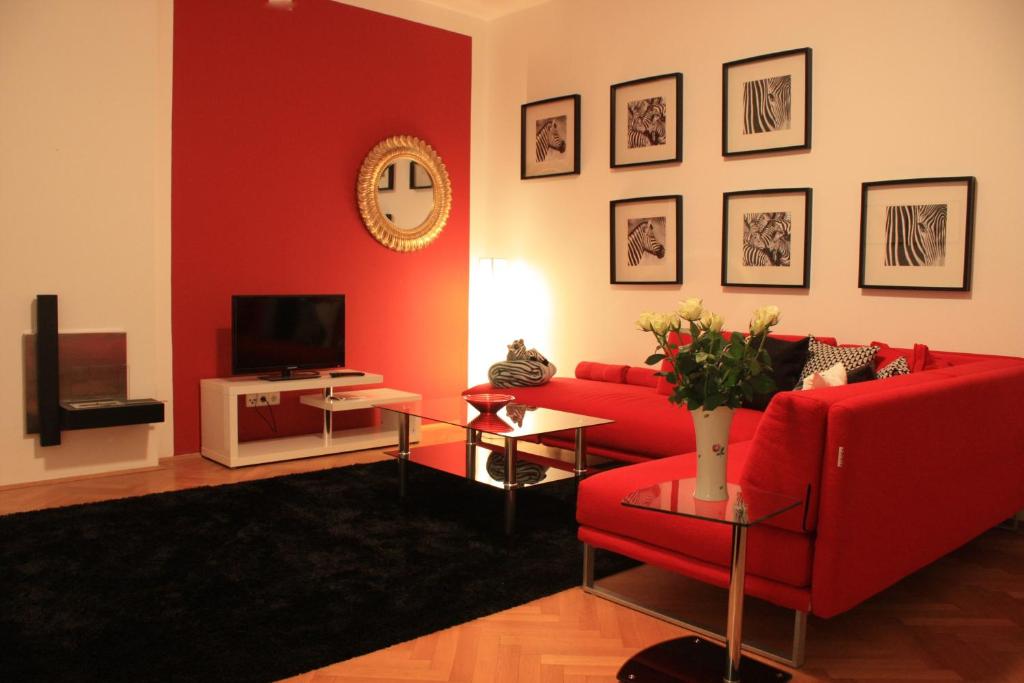 ein Wohnzimmer mit einem roten Sofa und einem TV in der Unterkunft Apartment Schönbrunn in Wien