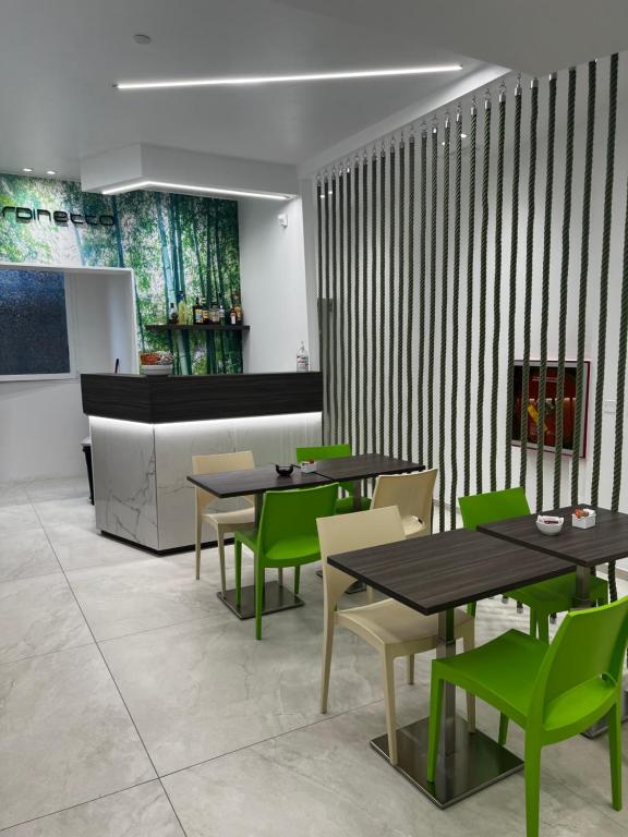 una sala da pranzo con tavoli e sedie verdi di Hotel Giardinetto Al Sant'Orsola a Bologna