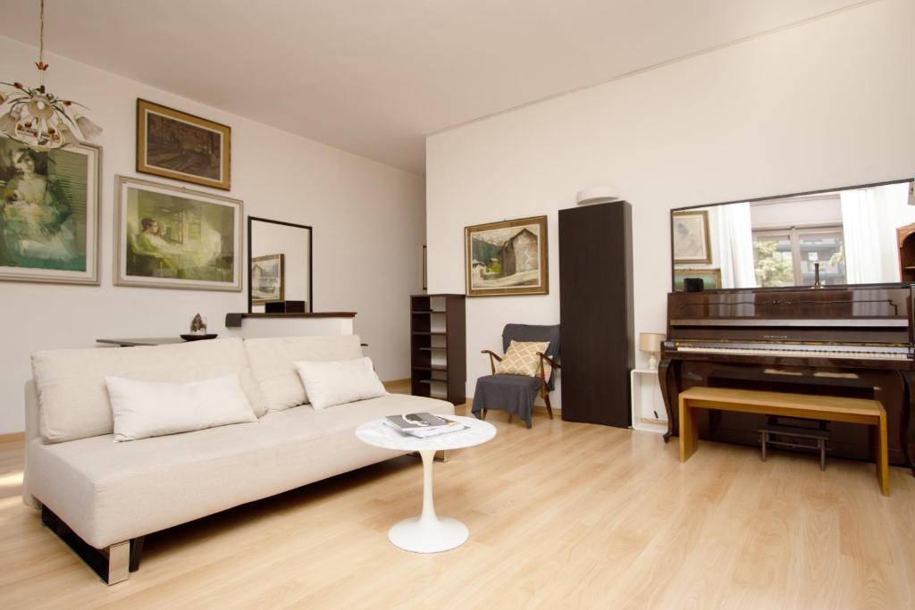 een woonkamer met een bank en een piano bij Note D'Artista-Duomo 15 minutes in Milaan