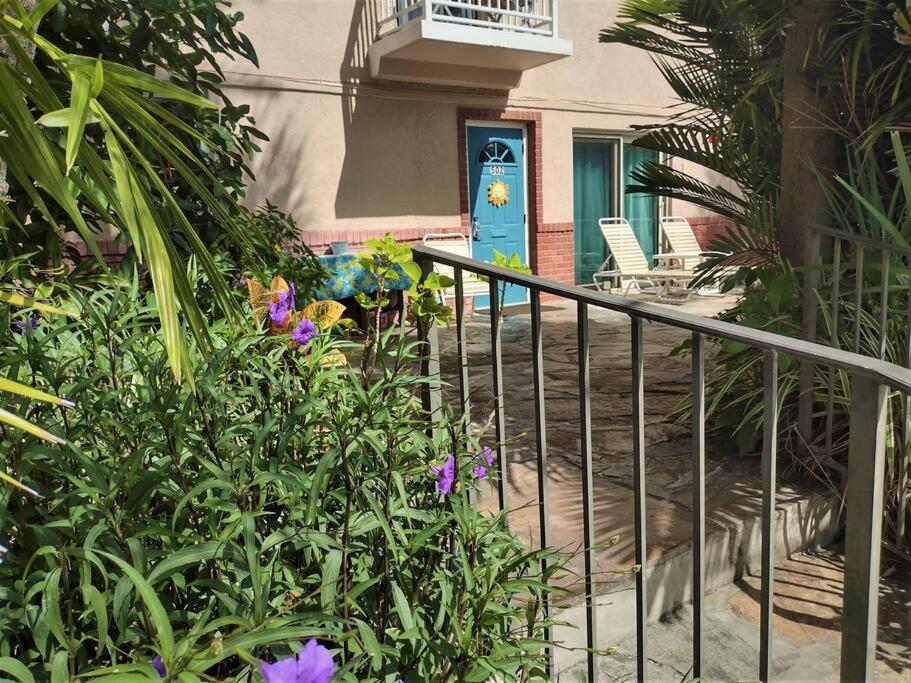 a house with a blue door and some flowers at Tropical Courtyard Paradise on St. Pete Beach in St. Pete Beach