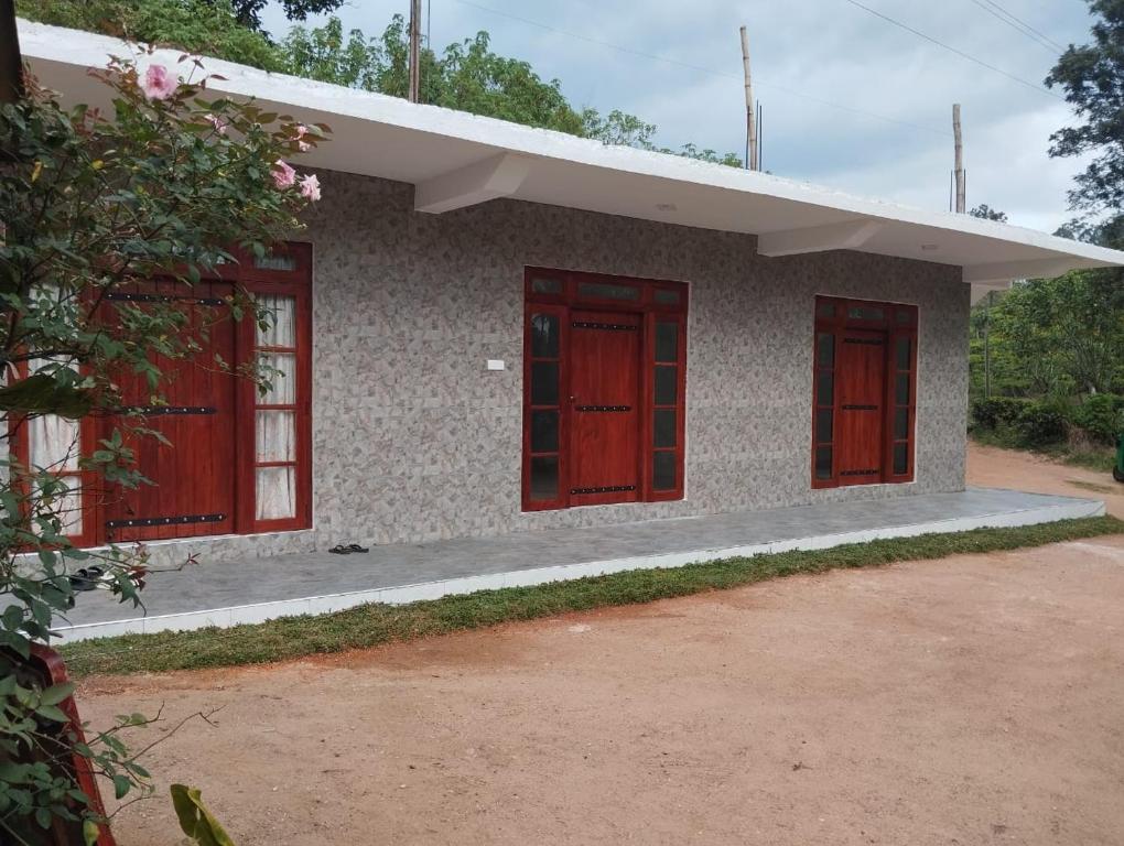 una pequeña casa con puertas rojas en WhyNot Guesthouse Ella en Ella