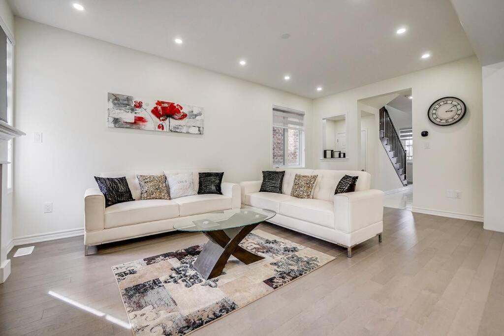 a living room with two white couches and a clock at 922 Logan Drive in Milton