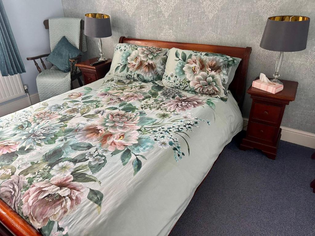 a bedroom with a bed with a floral bedspread at Manor Inn Galmpton in Brixham