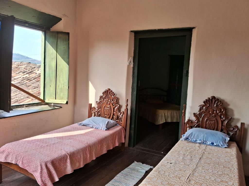 Casa por temporada في غوياس: سريرين يجلسون في غرفة مع نافذة