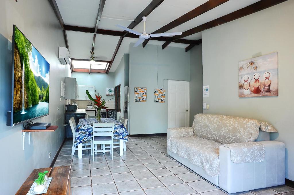 a living room with a couch and a table at Private Fully Furnished Home at Wide Mouth Frog Hostel Quepos in Quepos