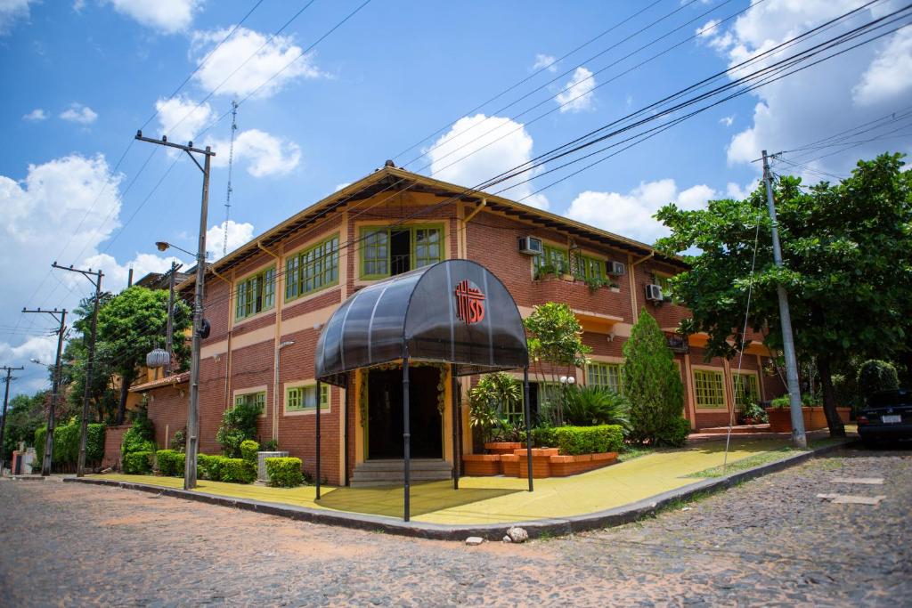 un edificio de ladrillo rojo con toldo negro en Hotel Santo Domingo, en Asunción