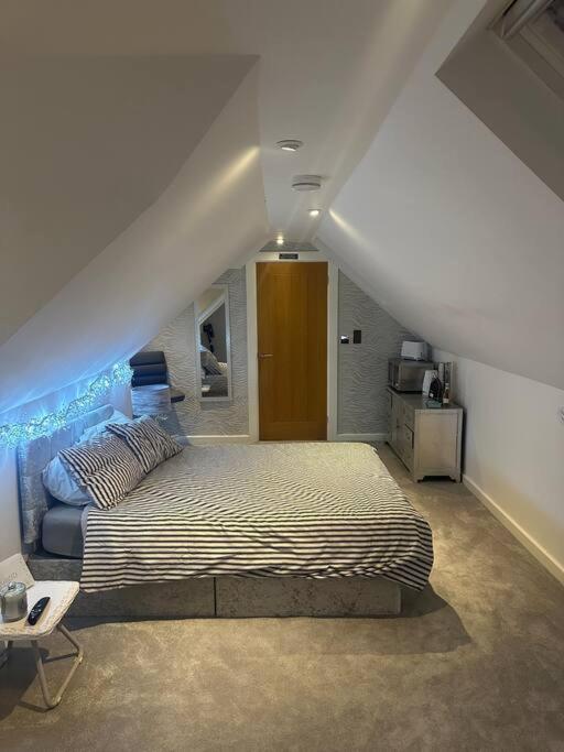 een slaapkamer met een groot bed op een zolder bij Cozy 1 bed Urban Haven in Swithland