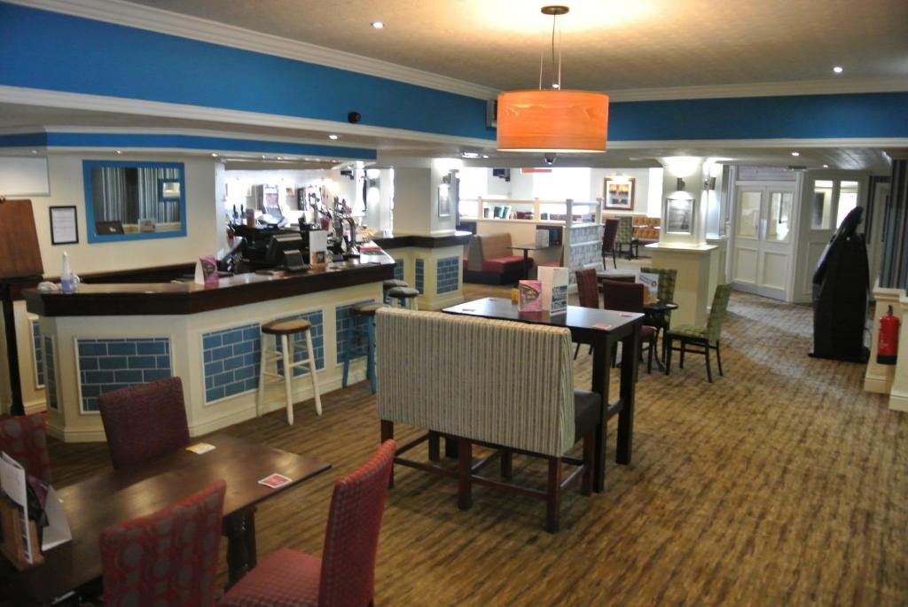 een restaurant met een bar en tafels en stoelen bij Pelham Hotel in Immingham