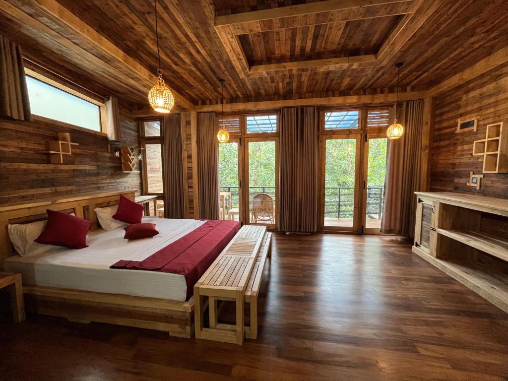 1 dormitorio con 1 cama grande en una habitación con paredes de madera en Winwood Ella en Ella