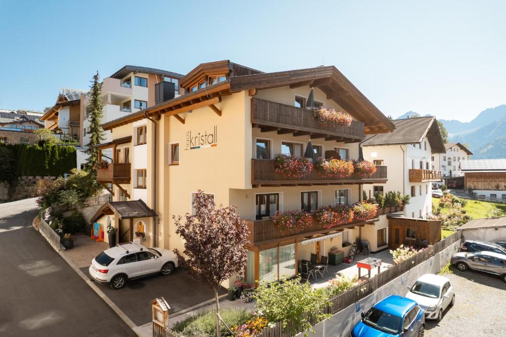 a building with cars parked in front of it at Haus Kristall inkl der SUPER SOMMER CARD im SOMMER 2026 in Serfaus