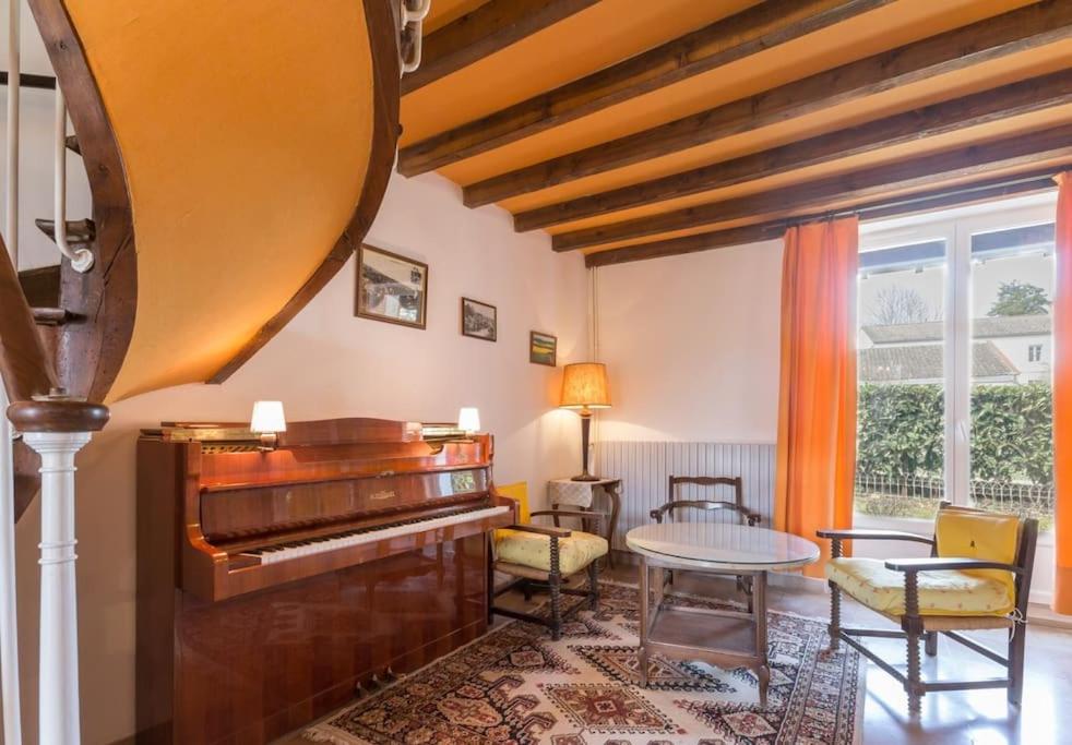 - un salon avec un piano et une table dans l'établissement L'Oenologîte, à Messanges