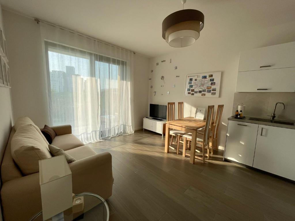 sala de estar con sofá, mesa y cocina en Stupendo appartamento in Fiera Milano-Up Town en Pero