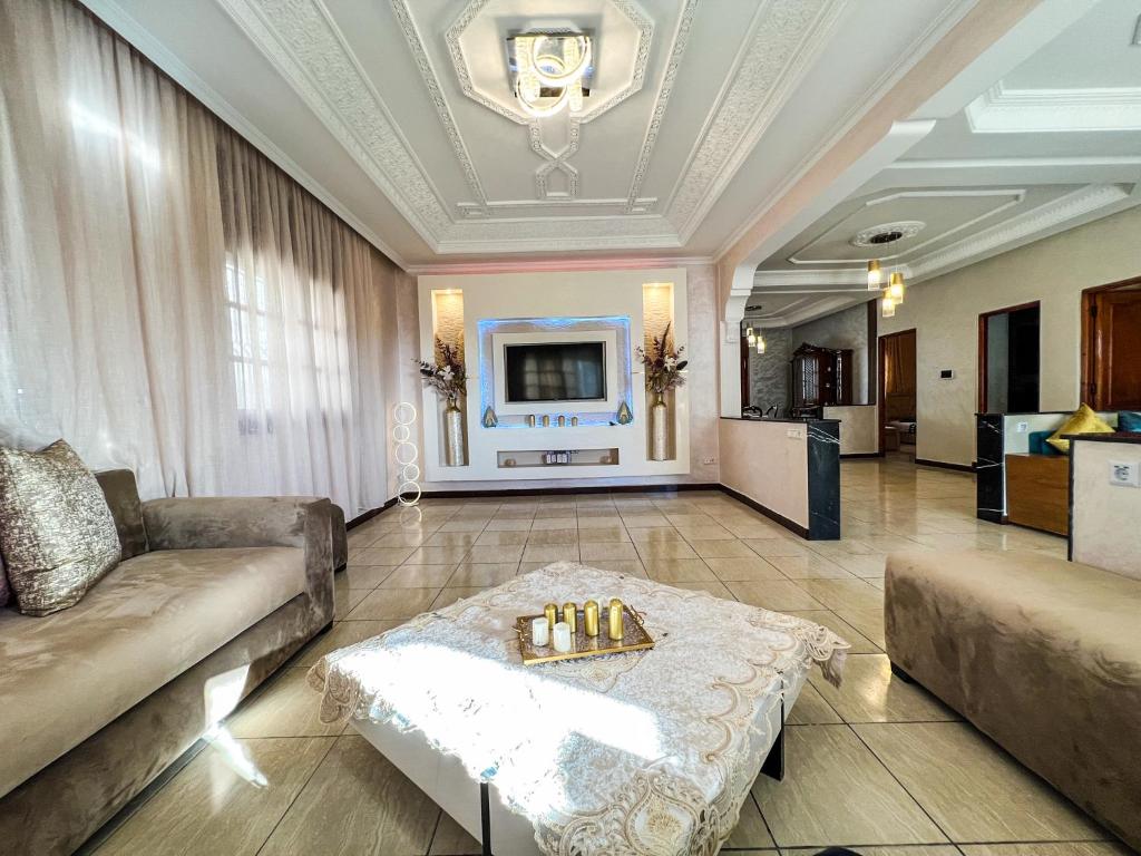 un soggiorno con un divano e un tavolo di Charatane, 2 bedroom, spacious & bright 100m² at 200m beach a Plage de Mehdia