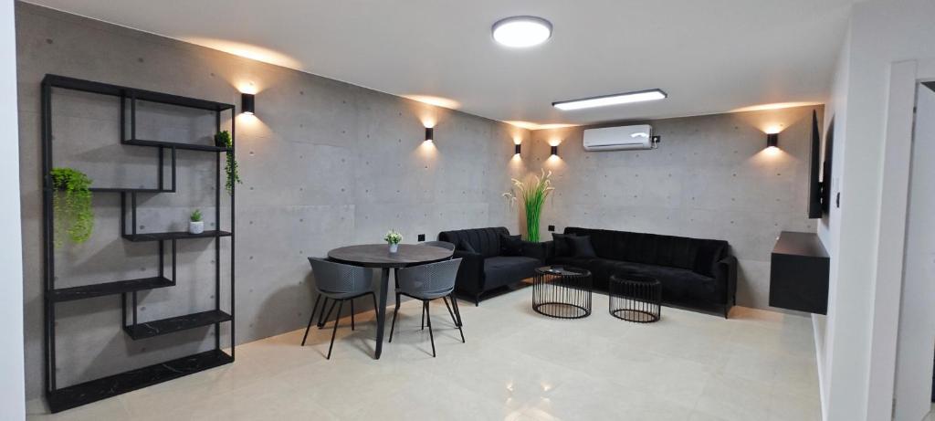 ein Wohnzimmer mit einem schwarzen Sofa und einem Tisch in der Unterkunft כוכב הצפון in Kirjat Schmona