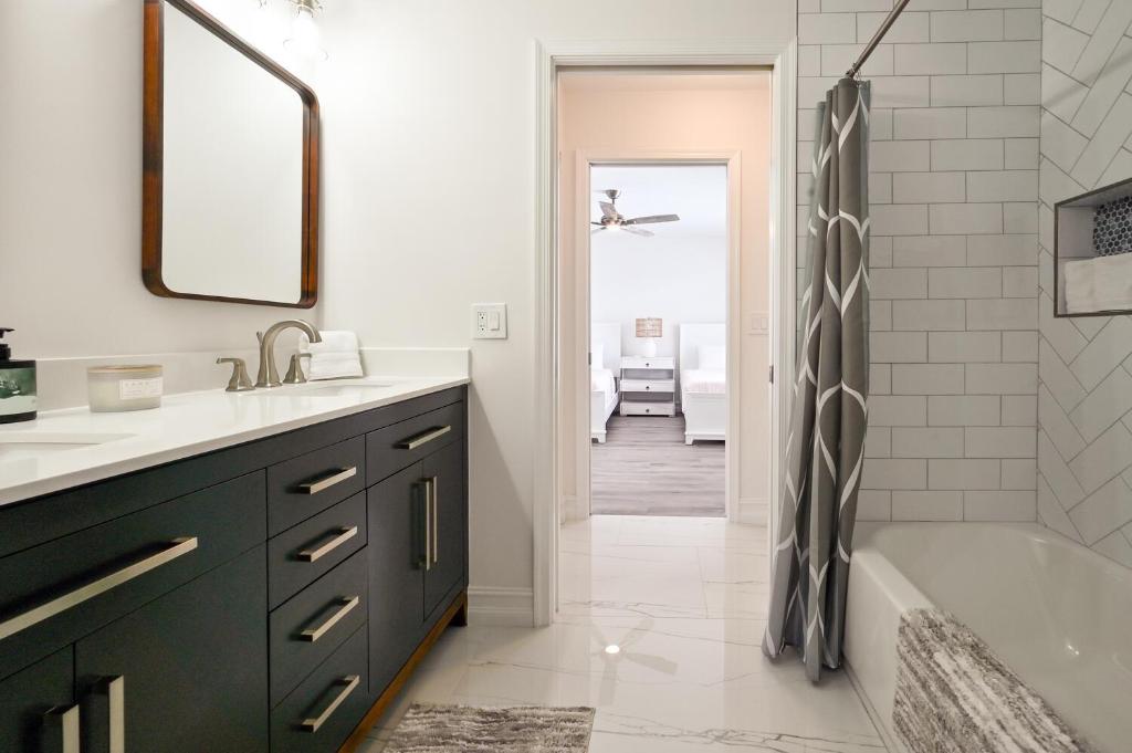 ein Badezimmer mit Waschbecken, Badewanne und Dusche in der Unterkunft Spacious+Cozy Home, near the beach, heated pool. in Naples