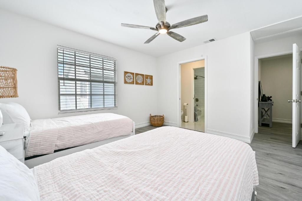 ein Schlafzimmer mit zwei Betten und einem Deckenventilator in der Unterkunft Spacious+Cozy Home, near the beach, heated pool. in Naples