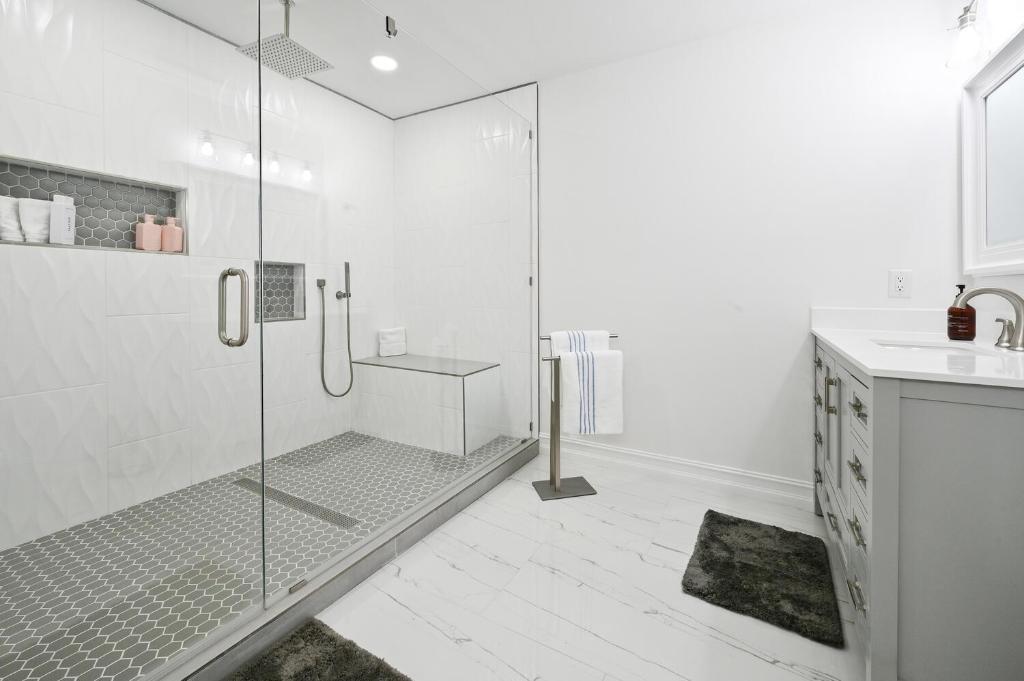 ein weißes Badezimmer mit Dusche und Waschbecken in der Unterkunft Spacious+Cozy Home, near the beach, heated pool. in Naples