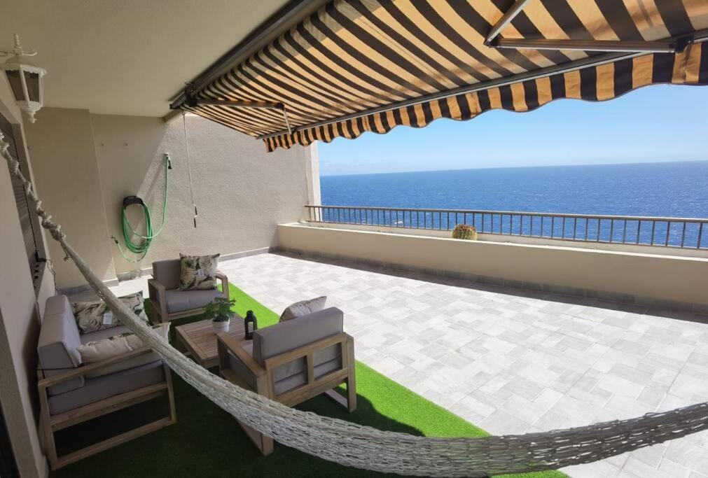 - un hamac sur un balcon avec vue sur l'océan dans l'établissement Apartamento vistas al océano, à Radazul