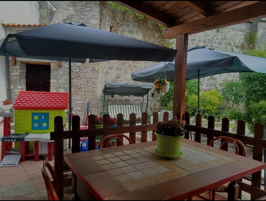 - une table avec un parasol et une maison de jouets sur une terrasse dans l'établissement La casa nel borgo, à Forlì del Sannio