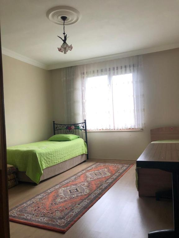 Un dormitorio con una cama verde y una ventana en Emine Yılmaz’ın Evi, en Araklı
