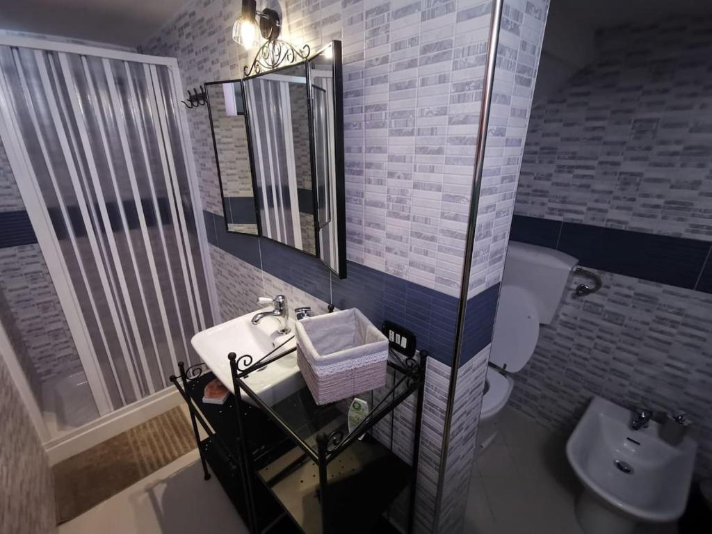 W łazience znajduje się umywalka, toaleta i lustro. w obiekcie The Best House w mieście Reggio nell'Emilia