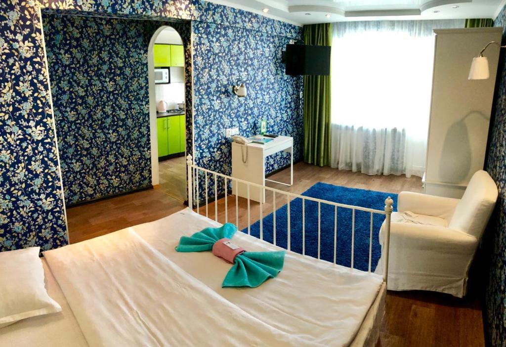 - une chambre avec un lit et une chaise dans l'établissement Шато, à Petropavlovsk-Kamtchatski