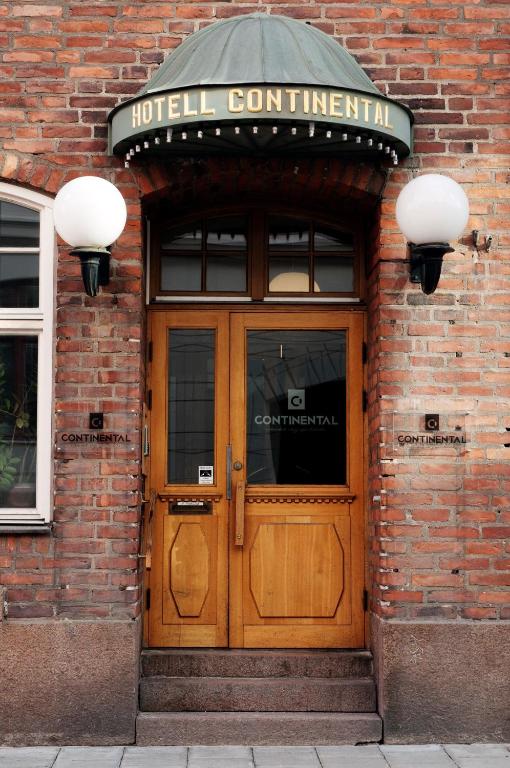 una puerta de entrada de madera a un edificio con una señal encima en Continental Apartment Hotel Sundsvall, en Sundsvall