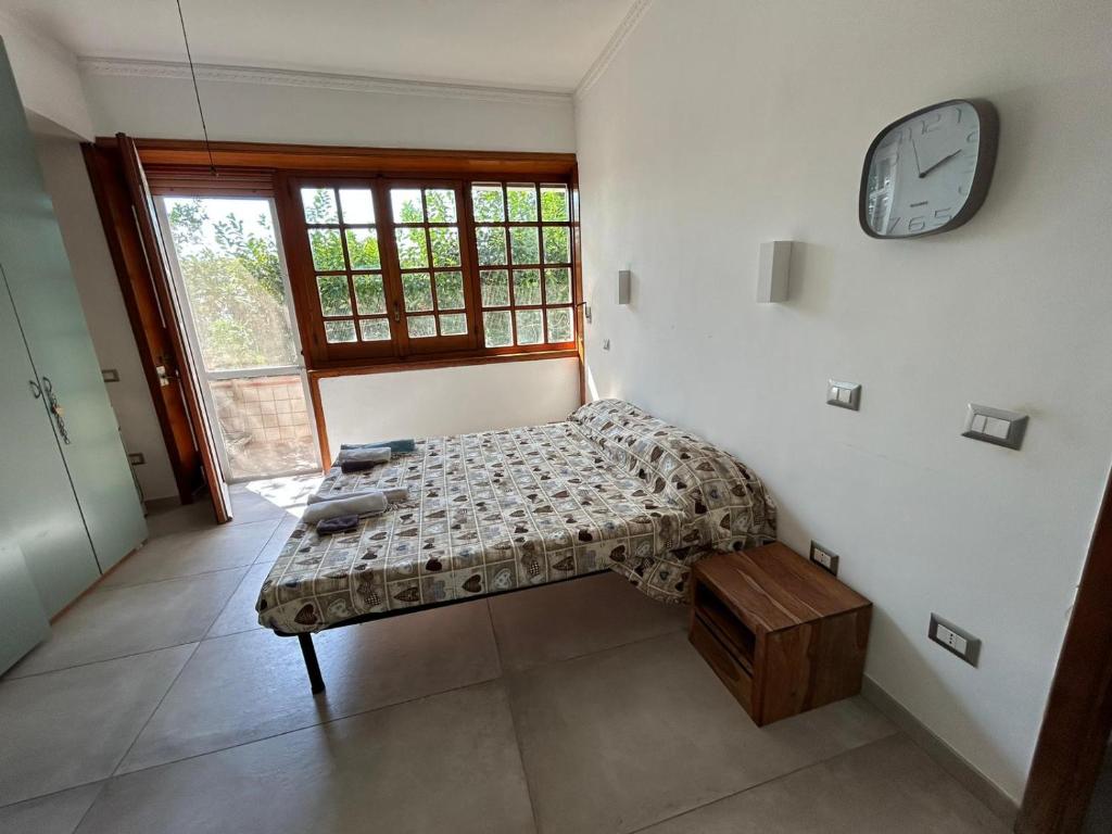 - une chambre avec un lit et une horloge murale dans l'établissement GrannyHome, à SantʼArpino